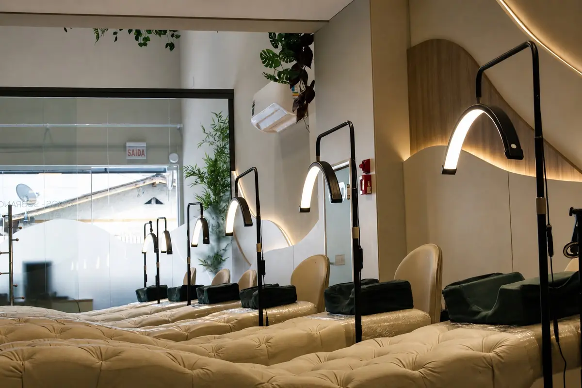 Sala de extensão de cílios do Deluca Studio Beauty com macas e luminárias