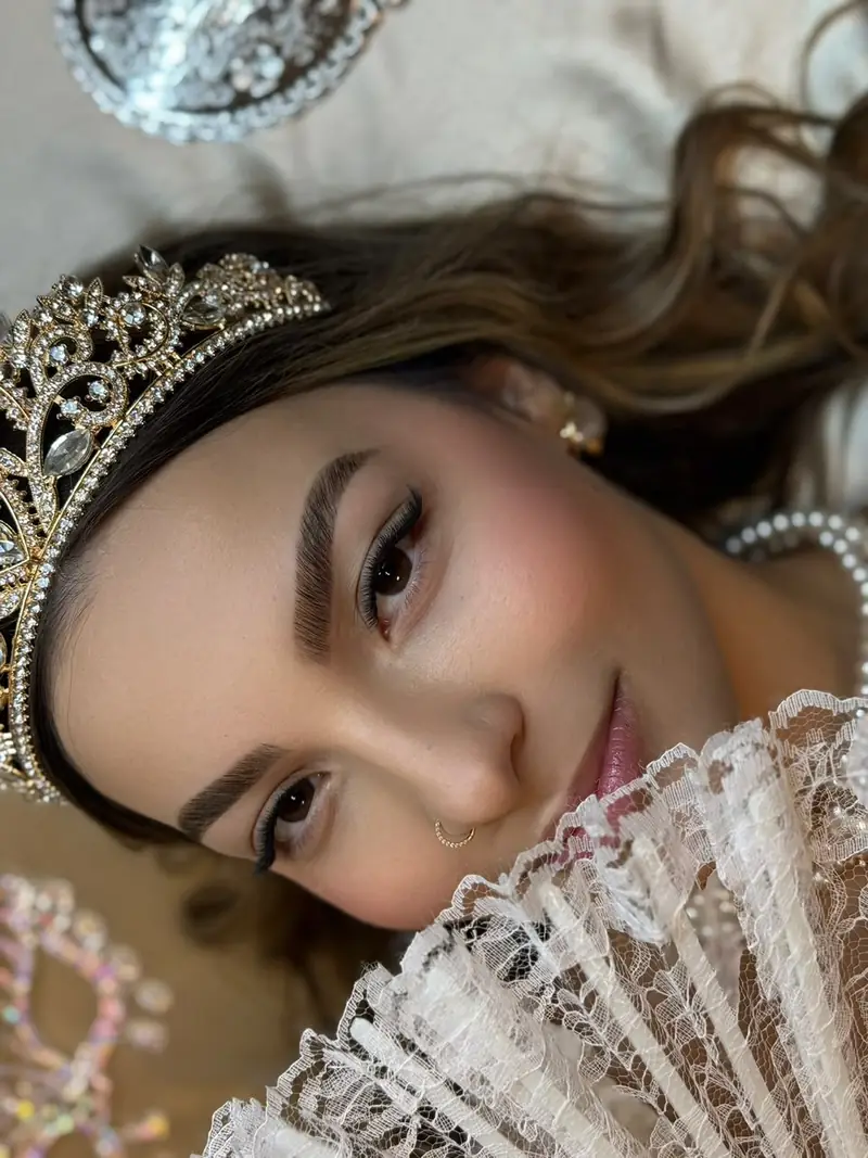 Cílios e sobrancelhas em modelo com coroa e leque — trabalho do Deluca Studio Beauty, Balneário Camboriú
