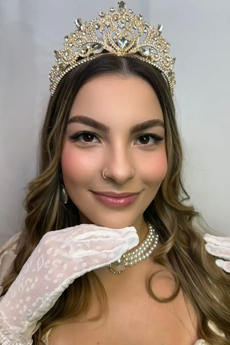Modelo com coroa e luvas de renda, cílios e sobrancelhas — trabalho do Deluca Studio Beauty, Balneário Camboriú