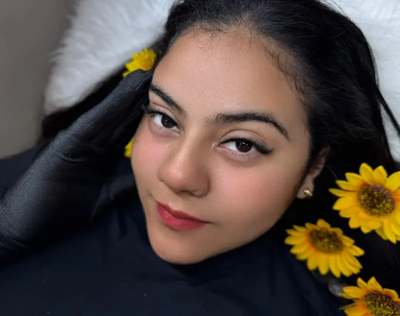 Modelo com girassóis e luvas pretas, olhar com cílios — trabalho do Deluca Studio Beauty, Balneário Camboriú