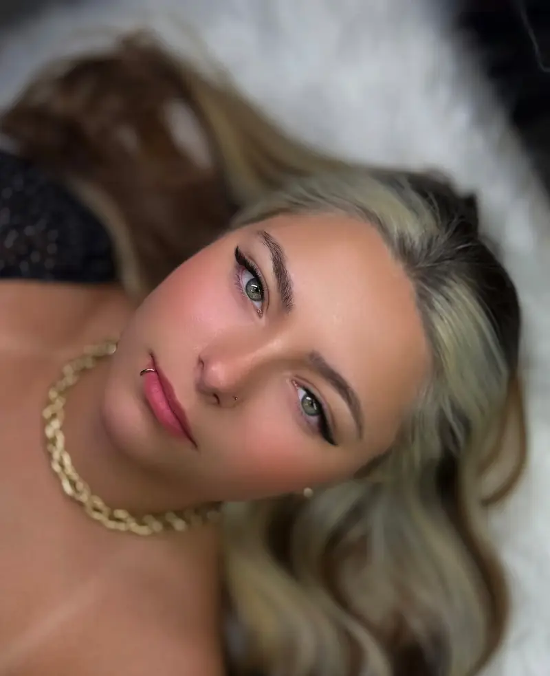 Modelo loira deitada com cílios e sobrancelhas — trabalho do Deluca Studio Beauty, Balneário Camboriú